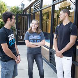 Students outside the Hilbert campus walkway, socializing.