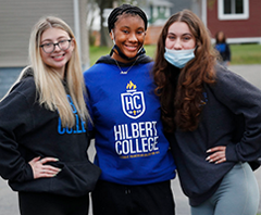 Three female students posing during Day of Caring at Hilbert College.