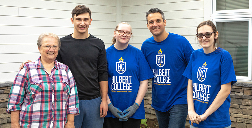 Students and staff help out in yard work during Day of Caring at Hilbert College