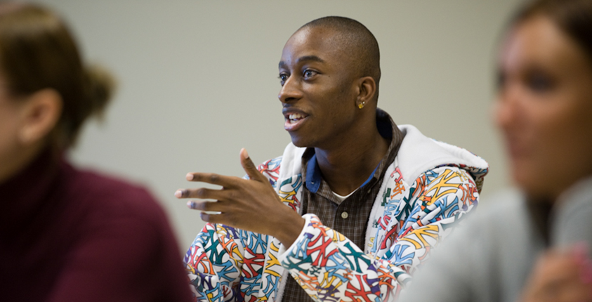 A male student talking in the classroom. 