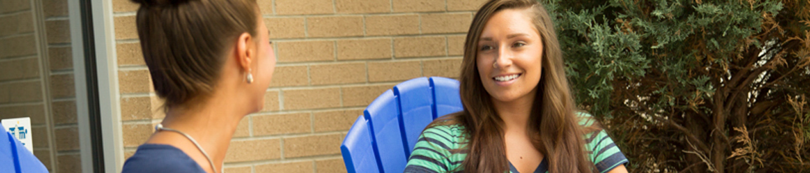 Two students lounging by the Hilbert apartments