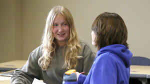 Students talking in a classroom.