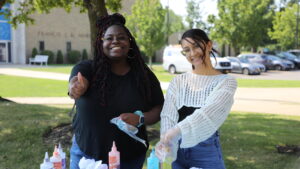 Hilbert students tie dyeing shirts on campus.
