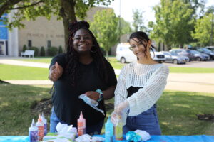 Hilbert students tie dyeing shirts on campus.
