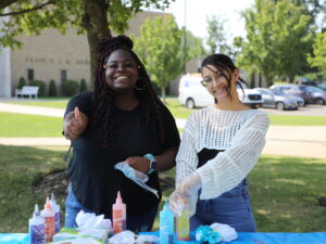Hilbert students tie dyeing shirts on campus.